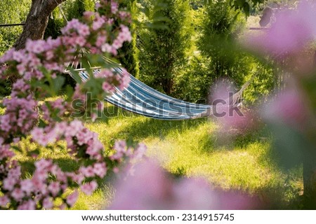 Close-up of a colorful hammock for relaxing in the garden. Beautiful photo of natural fabric hammock in location