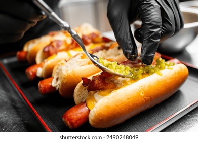 Close-up of colorful hot dogs with various toppings on a black surface - Powered by Shutterstock