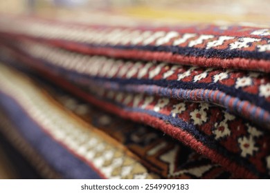 Close-up of colorful, intricately patterned rugs stacked together - Powered by Shutterstock