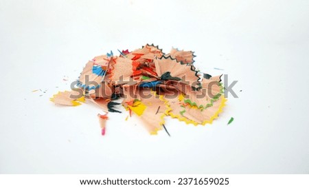 Close-up of colorful pencil shavings on a white background. Whole and broken lead pencils on white background. The rest of the pencil. Macro, pile of shavings