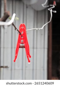 Close-up of colorful plastic clothespins clipped onto a clothesline with a blurred background. Bright and vibrant tones ideal for concept of laundry, summer, or household chores.