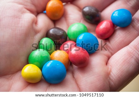 closeup of colorful round chocolate candies in hand