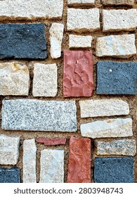 Close-up of the colorful texture of wall cladding made of stones of various shapes and colors