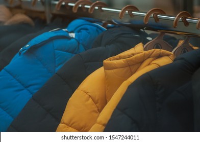 Closeup of colorful winter jackets on hangers in fashion store showroom - Powered by Shutterstock