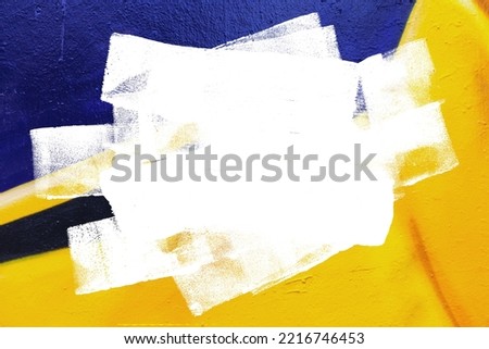 Closeup of colorful yellow and black urban wall texture with white white paint stroke. Modern pattern for design. Creative urban city background. Grunge messy street style background with copy space