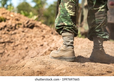 Close-up at combat shoe of a  infantryman soldier who wearied camouflage uniform during  standing on the battlefield ground. Selective focus at part of the shoe. - Powered by Shutterstock