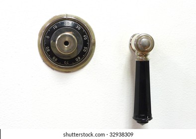 Closeup of a combination dial and latch-lever of an older, vintage vault or safe.