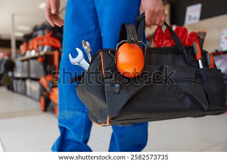 Closeup of comfortable ergonomic bag for work tools and personal protective equipment. Cropped shot of repairman or construction worker carrying toolbox handbag