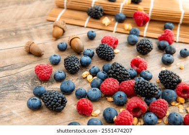Close-up composition, assorted mix berries: blackberries, blueberries, raspberries top view flat lay in a plate. Isolated on a wooden table background