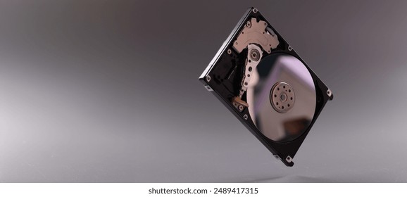 Close-up of computer hard disk drive with open cover. Hardware, hard disk and storage device. Detail of inside of hard disk drive