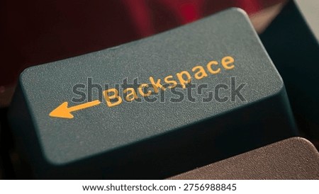 Close-up of computer keyboard backspace key with yellow text and arrow
