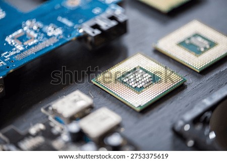 Close-up of computer microchips and circuit boards on a table, showcasing intricate electronic components and technology design elements.