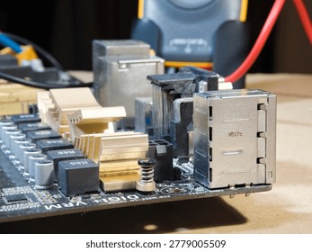 Close-up of Computer Motherboard Components; Macro shot showcasing dusty electronic components, gold heatsinks, and capacitors on a dark PC motherboard, symbolizing repair, technology, and hardware.