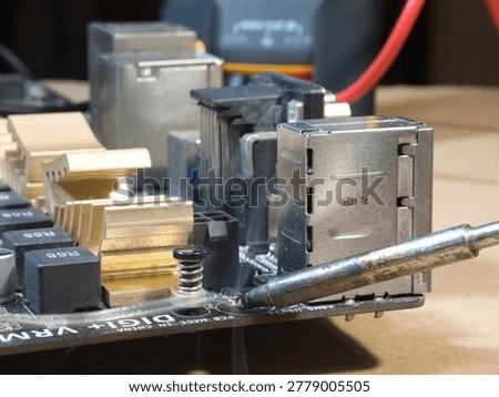 Close-up of Computer Motherboard Components; Macro shot showcasing dusty electronic components, gold heatsinks, and capacitors on a dark PC motherboard, symbolizing repair, technology, and hardware.