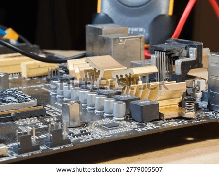 Close-up of Computer Motherboard Components; Macro shot showcasing dusty electronic components, gold heatsinks, and capacitors on a dark PC motherboard, symbolizing repair, technology, and hardware.