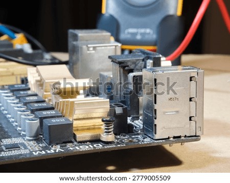 Close-up of Computer Motherboard Components; Macro shot showcasing dusty electronic components, gold heatsinks, and capacitors on a dark PC motherboard, symbolizing repair, technology, and hardware.