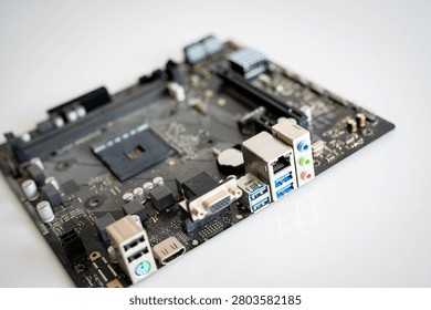 Close-up computer motherboard with processor socket and multiple input output ports, showcasing modern PC hardware, electronics, computer engineering, connectivity and digital technology on a clean background.