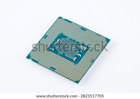 Close-up of a computer processor chip showing contact pads and circuitry on a clean white background.