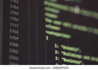 Close-up of computer screen displaying lines of code in a dark environment.
