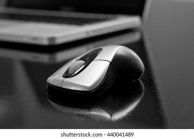 Closeup of a computermouse in front of a laptop