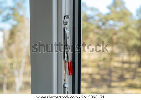 Close-up of concealed handle on second window sash. Detailed view of a hidden tilt-and-turn window handle used to open the passive sash in modern PVC window systems.