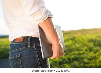 Closeup Of Confident Business Woman Holding Tablet Pc Or Ipad Outside In Front Of Sunset.  Woman Looking To The Future.