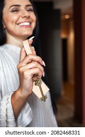 Closeup confident female hands holding keys from new house feeling happiness buying apartment. Woman owner of new flat or real estate agent carrying key unlock access property symbol of independence