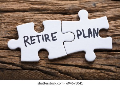 Closeup Of Connected Retire Plan Jigsaw Pieces On Wood