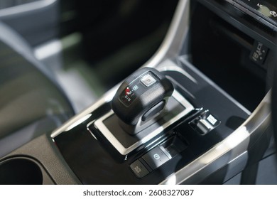 close-up of a contemporary automatic gear shift knob in a glossy car console, highlighting convenience, style, and interior automotive design.