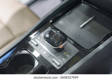 close-up of a contemporary automatic gear shift knob in a glossy car console, highlighting convenience, style, and interior automotive design.
