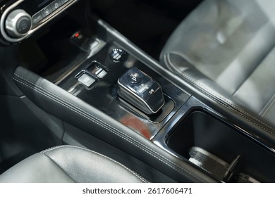 close-up of a contemporary automatic gear shift knob in a glossy car console, highlighting convenience, style, and interior automotive design.