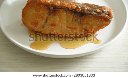 A close-up of cooked beef steak on a white dish with sauce, simple and tasty