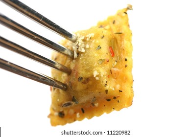 Closeup of cooked ravioli on a fork isolated on a white background