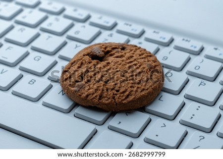 Close-up of a cookie on a computer keyboard. Internet cookies, technology, and online privacy concepts.