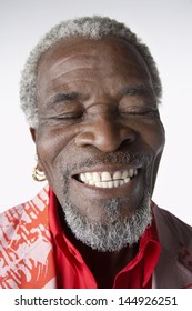 Closeup of a cool smiling senior man with eyes closed against white background