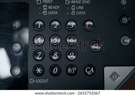 Close-up of a copier or printer control panel, with number pad, function buttons, and status lights for printing and sending images.
