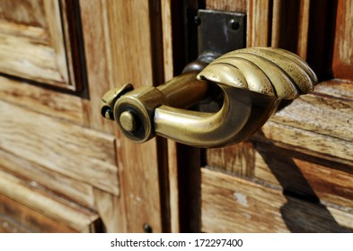 Close-up Of A Copper Doorknob And Wood Door