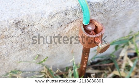 Close-up of copper electrical grounding rods. Metal grounding rods pinned into the ground on the side of the cement floor to prevent short circuits with a copy space. Selective focus