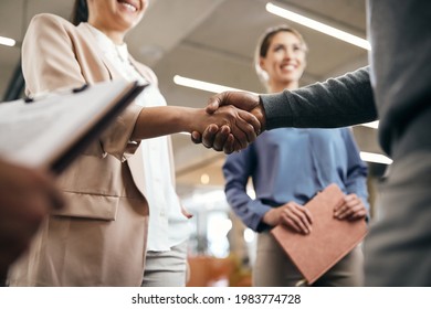 Close-up of corporate managers handshaking after successful agreement in the office.