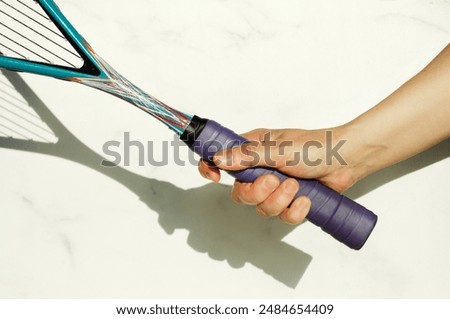 Close-up of the correct grip of a squash racket. Hand holding a racket on a white background, space for text, copy space
