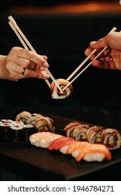 Close-up, couple hands eating sushi food with chopsticks