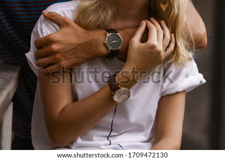 Close-up of couple hands. Well dressed stylish man and woman wearing wristwatches.