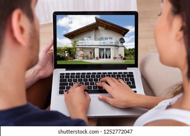 Close-up Of A Couple Looking For New House On Laptop