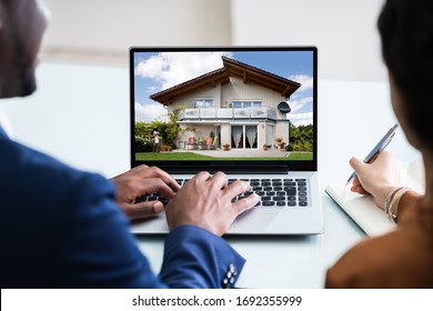 Close-up Of A Couple Looking For New House On Laptop