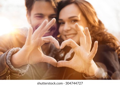 Closeup of couple making heart shape with hands - Shutterstock ID 304744727