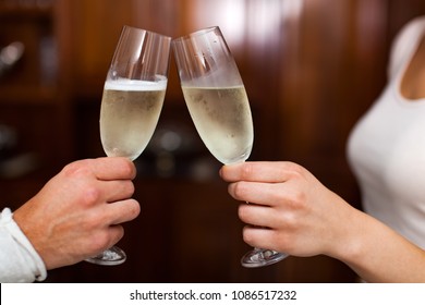 Closeup of a couple toasting wine glasses