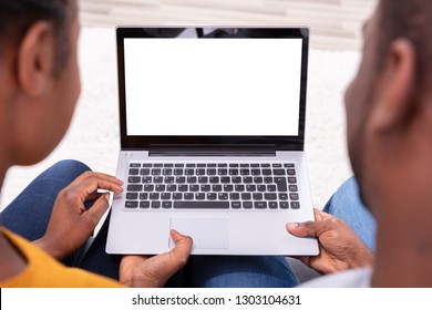 Close-up Of A Couple Using Laptop With Blank White Screen