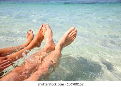 Closeup of couple's feet in lagoon water