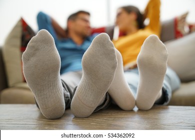 Closeup of couple's feet laid on table