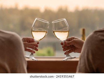 Closeup of couple's hands enjoying a glass of wine at home and a beautiful relaxing nature view  - Powered by Shutterstock